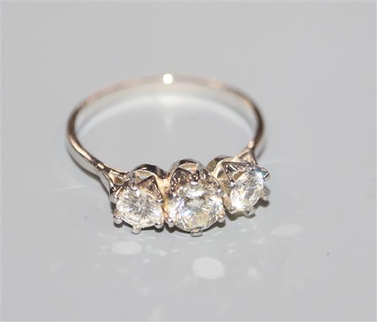 An 18kt white metal and three stone diamond ring, total diamond weight approximately 1.00ct, size O.